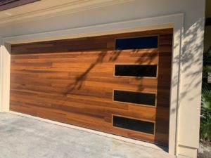 A garage door with wood paneling and black windows.