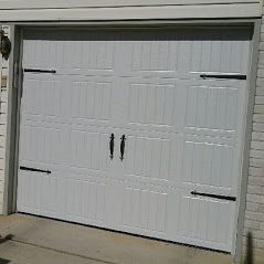 A white garage door with two black handles.