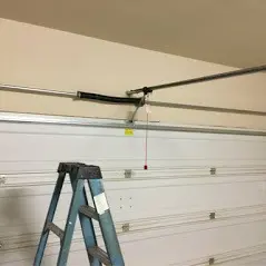 A ladder in the middle of a garage door.